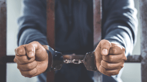 A man in a suit and tie holding his hands out.